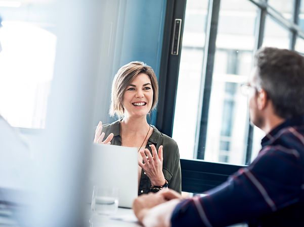 Frau erklärt im Büro die Vorteile von Secure SD-WAN – Juniper