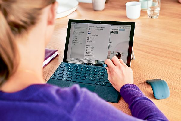 Eine Frau arbeitet am Laptop und informiert sich über T Cloud Public