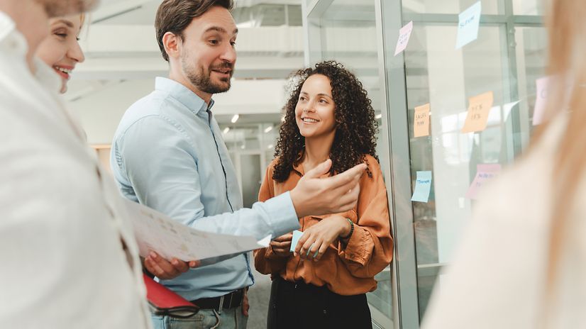 Mehrere Personen arbeiten zusammen im Großraumbüro und sprechen über Hubdrive