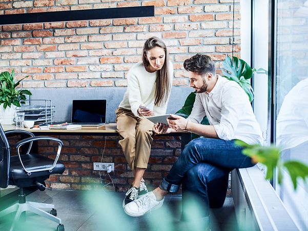 Frau und Mann unterhalten sich im Büro
