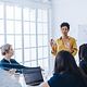 Weibliche Projektleiterin bei einer Besprechung zum Thema Magenta Security Assessments & Audits mit ihrem Team in einem Büro