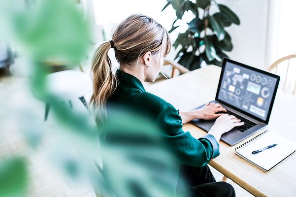 Eine Geschäftsfrau schaut sich Analysedaten auf ihrem Notebook an