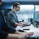 Ein Security Spezialist arbeitet an einem Desktop-Computer und überwacht IT-Systeme mittels Cyber Defense Lösungen