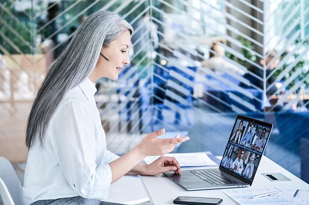 IT-Expertin mit Headset im modernen Büro hält ein Zoom X Webinar