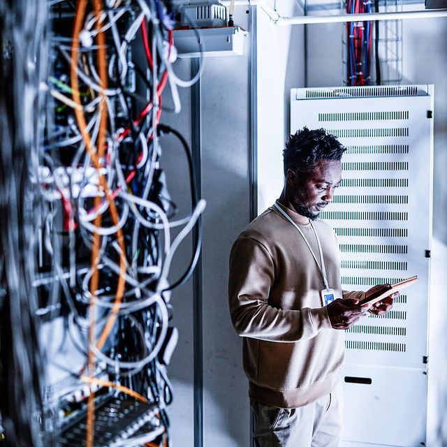 Ein Techniker steht vor einem Serverschrank der Telekom