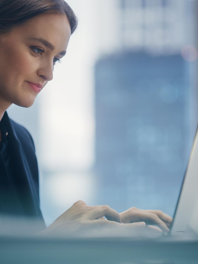 Frau sitzt am Laptop und lädt einen Cisco Headset Flyer herunter 