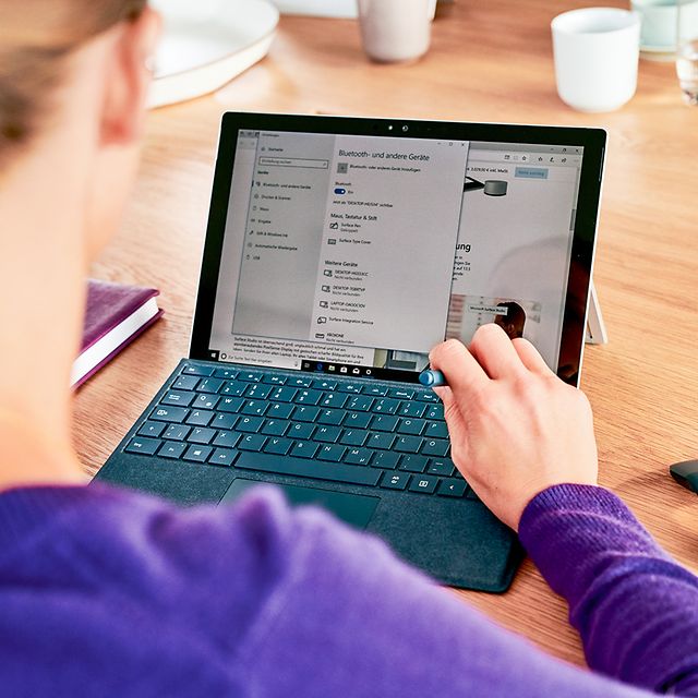 Eine Frau informiert sich am Laptop über Managed Backup to Cloud
