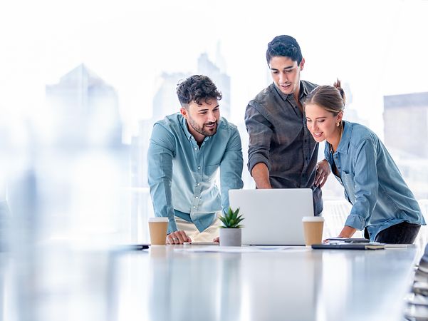 Business-Team, das in einem Sitzungssaal steht und an einem Laptop-Computer arbeitet