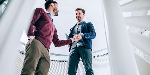 Zwei Männer besiegeln per Handschlag eine Vereinbarung.