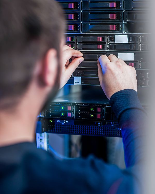 Ein Mitarbeiter nimmt Einstellungen an einem Server vor, um das Netzwerk per Cisco Meraki Managed Service zu skalieren.