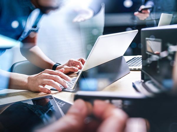 Nahaufnahme von Händen einer Person, die am Tablet arbeitet, um Edge-Computing-Lösungen der T-Systems zu entwickeln