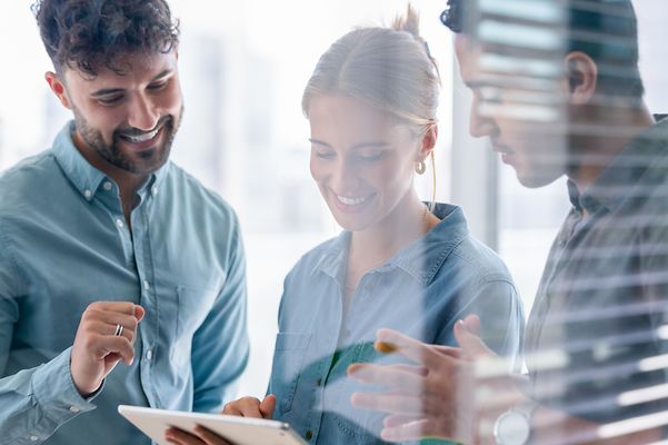 Business-Team mit Blick auf ein digitales Tablet.