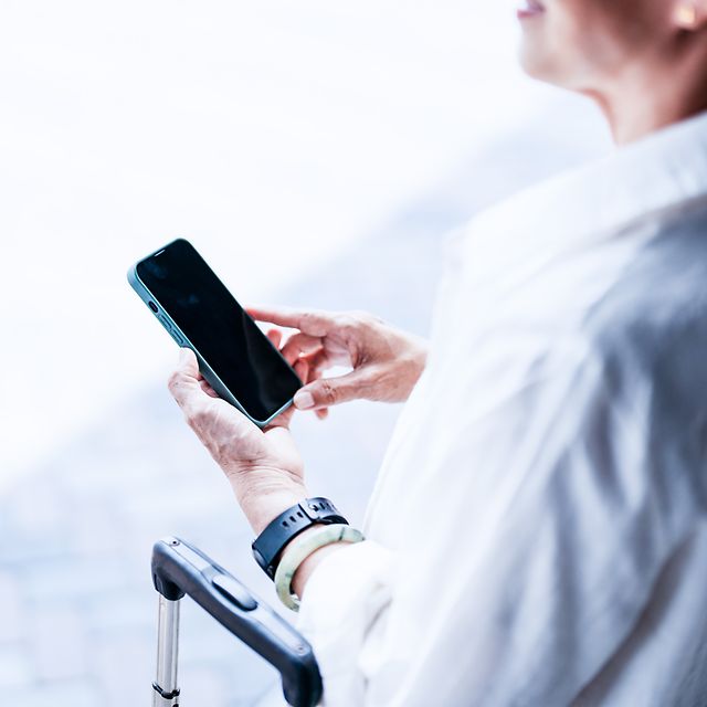 Geschäftsreisende nutzt Ihr Smartphone für eine sichere Datenübertragung