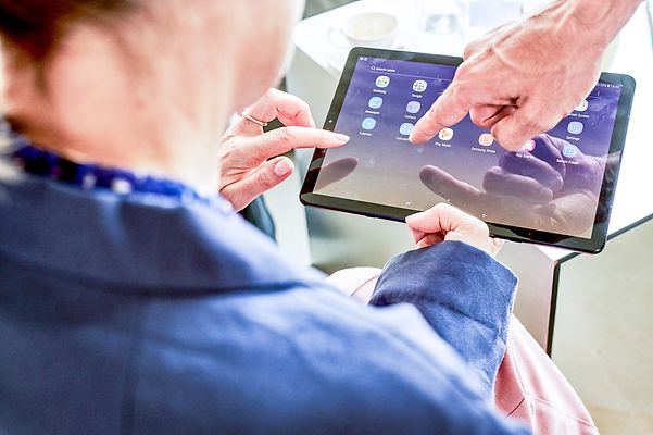 Geschäftskunde informiert sich über die T Cloud Public auf dem Tablet.